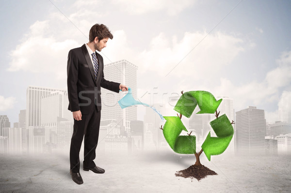 Business man watering green recycle sign tree on city background Stock photo © ra2studio