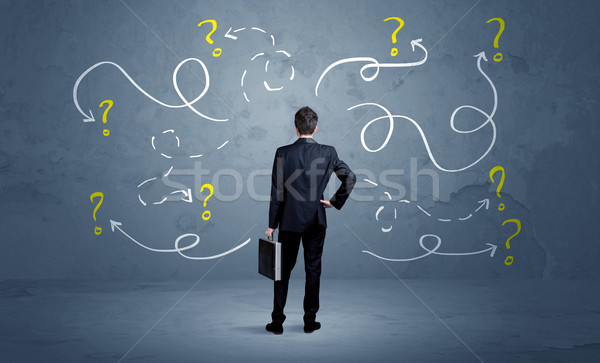 Unsure businessman with question marks Stock photo © ra2studio