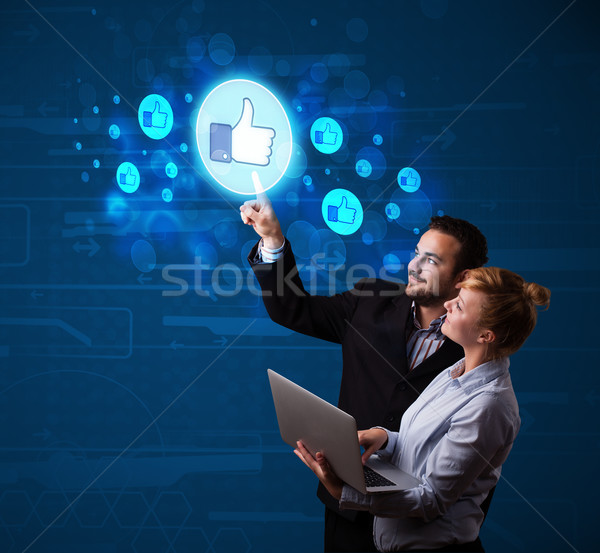 Young business couple pressing thumbs up button on modern social Stock photo © ra2studio