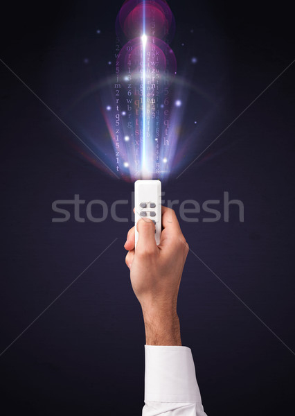 Hand with remote control and shining numbers Stock photo © ra2studio