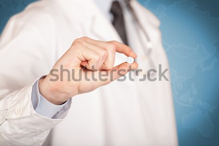 Doctor in white holding a pill Stock photo © ra2studio