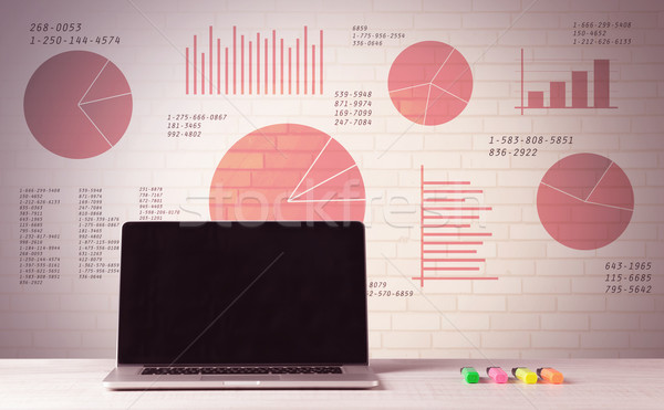 Laptop on office desk with sales pie charts Stock photo © ra2studio