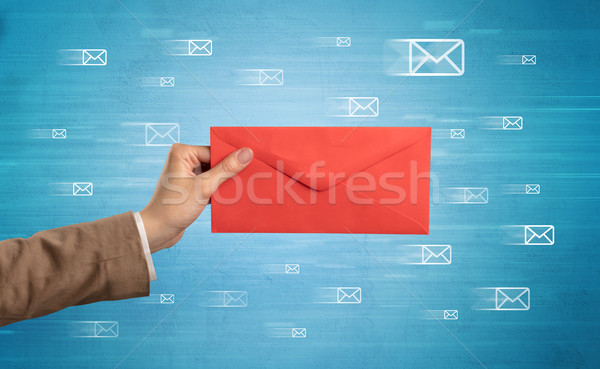 Hand holding envelope with message symbols around Stock photo © ra2studio