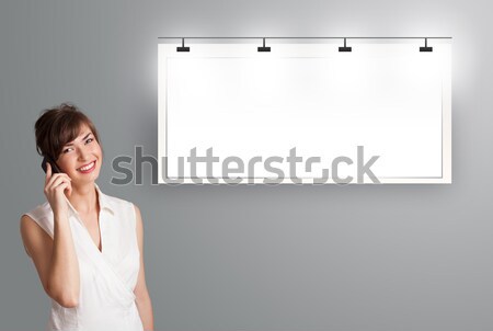 beautiful young woman standing next to a modern copy space and making phone call Stock photo © ra2studio