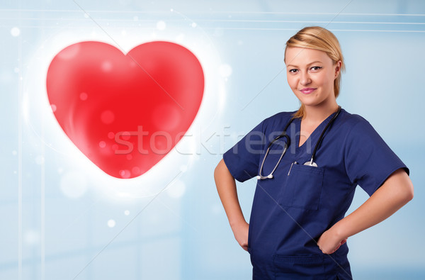 Jóvenes enfermera curación rojo corazón bastante Foto stock © ra2studio