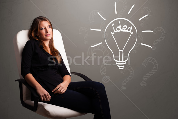 Stock photo: Young girl comming up with a light bubl idea sign