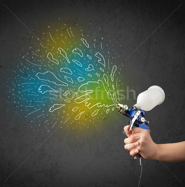 Worker with airbrush gun paints colorful lines and splashes Stock photo © ra2studio