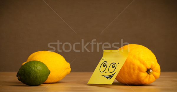 Lemon with post-it note looking at citrus fruits Stock photo © ra2studio