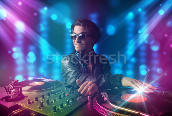 Dj mixing music in a club with blue and purple lights Stock photo © ra2studio