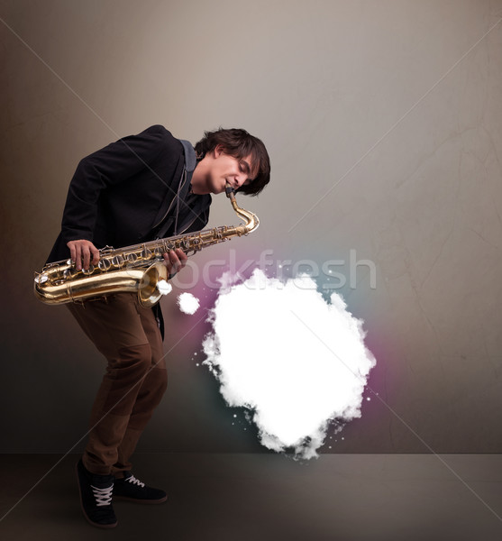 Young man playing on saxophone with copy space in white cloud Stock photo © ra2studio