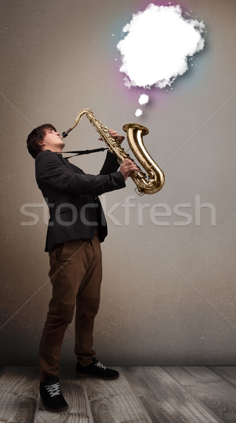 Young man playing on saxophone with copy space in white cloud Stock photo © ra2studio