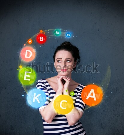 Young woman thinking with vitamins circulation around her head Stock photo © ra2studio