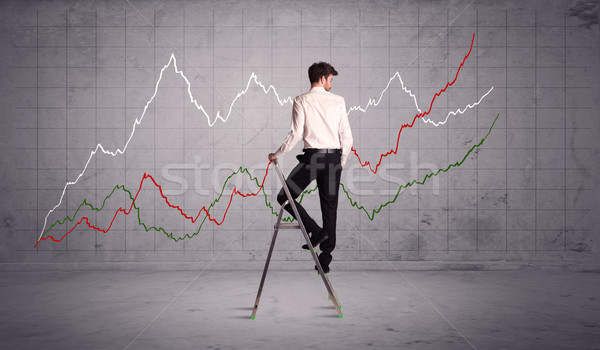 Stock photo: male on ladder drawing chart lines