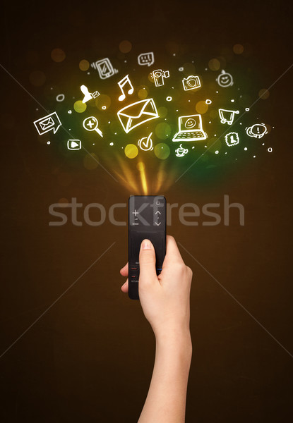 Hand with remote control and social media icons Stock photo © ra2studio