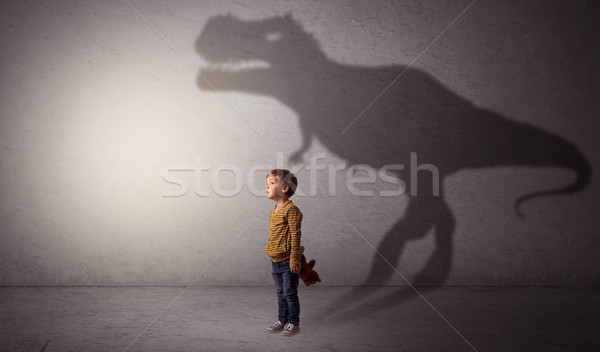 Stock photo: Dinosaurus shadow behind cute boy