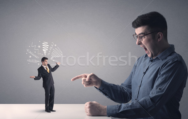 Young businessman fighting with miniature businessman Stock photo © ra2studio