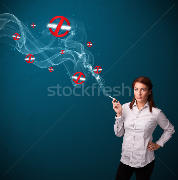 Stock photo: Young woman smoking dangerous cigarette with no smoking signs