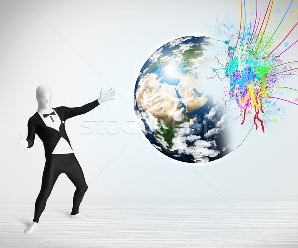 Funny man in body suit looking at colorful splatter earth Stock photo © ra2studio