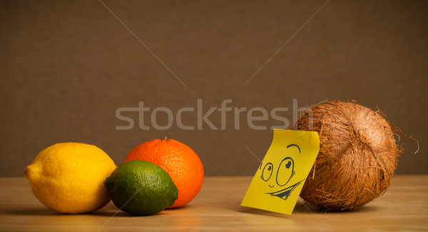 Coconut with post-it note looking curiously at citrus fruits Stock photo © ra2studio