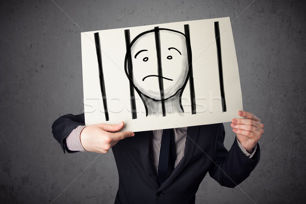 Businessman holding a paper with a prisoner behind the bars on i Stock photo © ra2studio