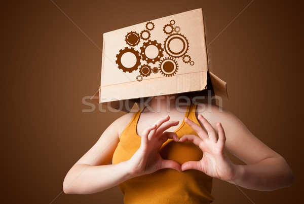 Young woman gesturing with a cardboard box on his head with spur Stock photo © ra2studio