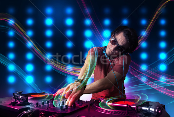 Young Dj mixing records with colorful lights Stock photo © ra2studio