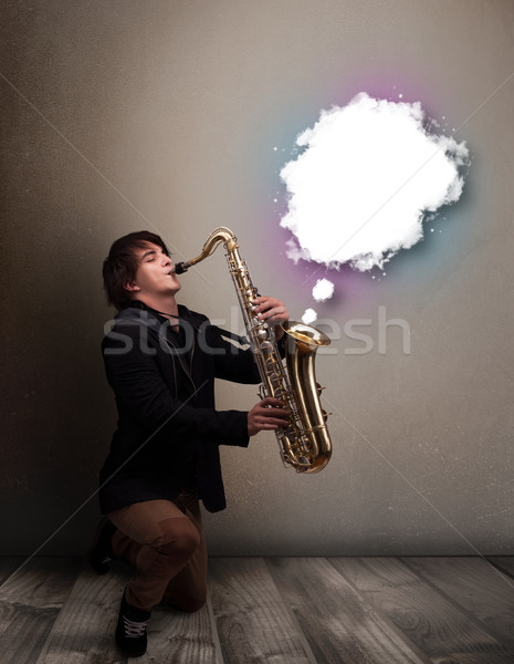 Young man playing on saxophone with copy space in white cloud Stock photo © ra2studio