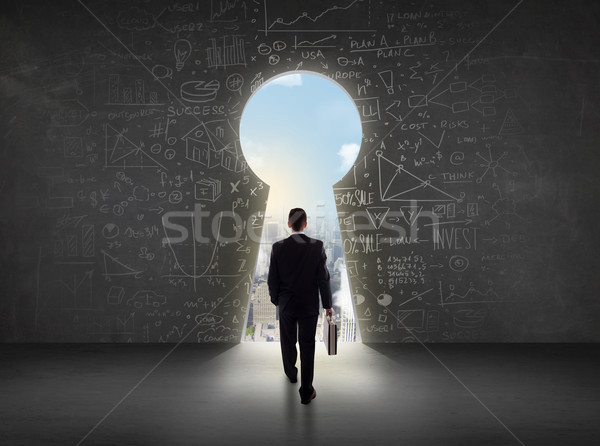Stock photo: Business man looking at keyhole with bright cityscape concept 