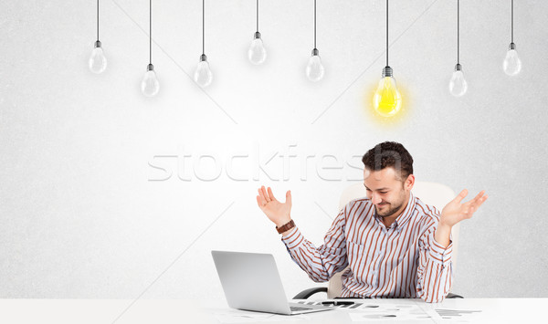 Business man sitting at table with idea light bulbs Stock photo © ra2studio