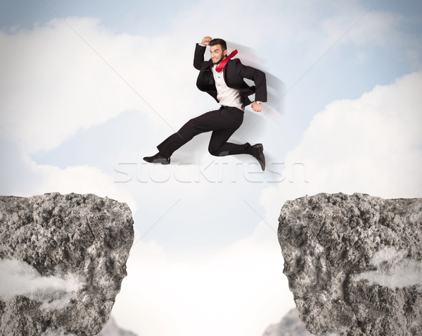 Funny Geschäftsmann springen Felsen Lücke Business Stock foto © ra2studio