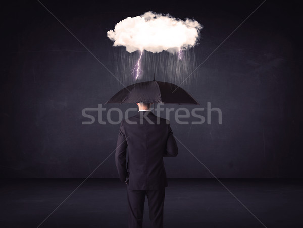Businessman standing with umbrella and little storm cloud Stock photo © ra2studio