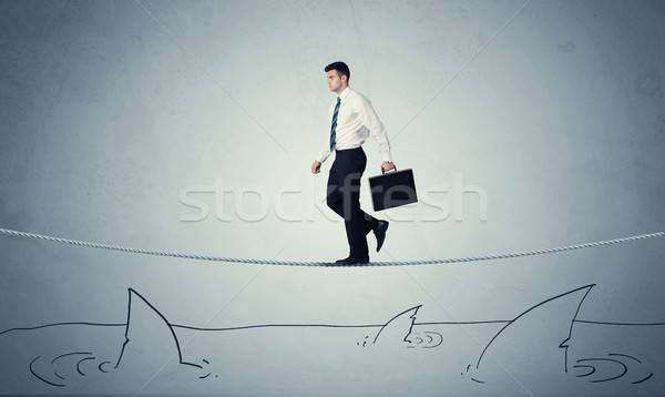 Businessman walking on rope above sharks Stock photo © ra2studio