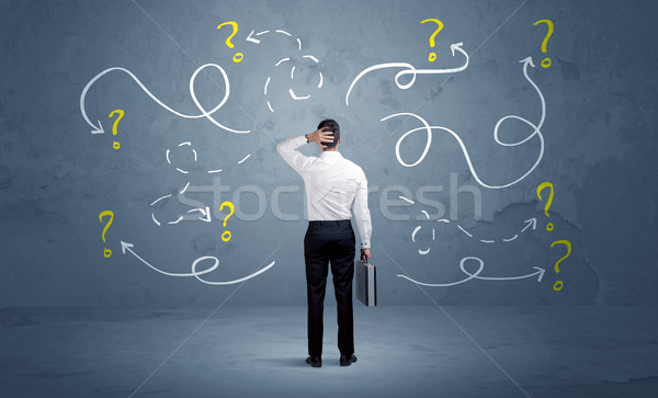 Unsure businessman with question marks Stock photo © ra2studio