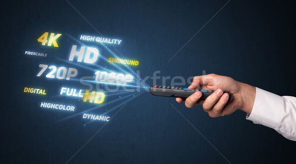 Hand with remote control and multimedia properties Stock photo © ra2studio