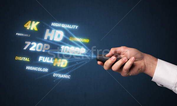 Hand with remote control and multimedia properties Stock photo © ra2studio
