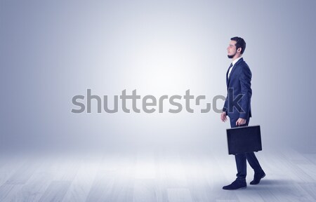 Businessman walking in front of an empty wall Stock photo © ra2studio