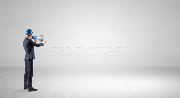 Architect standing in an empty space and holding a plan Stock photo © ra2studio