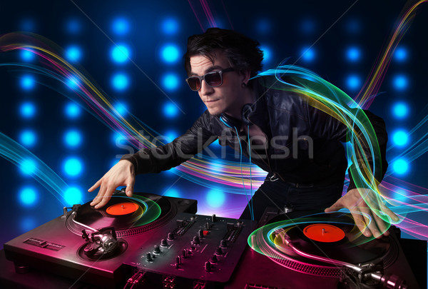 Young Dj mixing records with colorful lights Stock photo © ra2studio