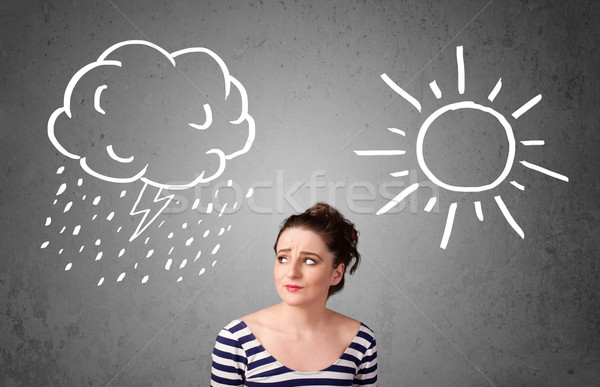 Stock photo: Woman standing between a sun and a rain drawing