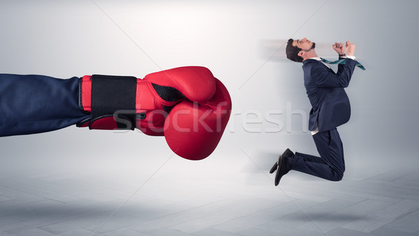 Giant hand gives a kick to a small businessman Stock photo © ra2studio
