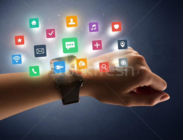 Female hand wearing smartwatch with app icons Stock photo © ra2studio