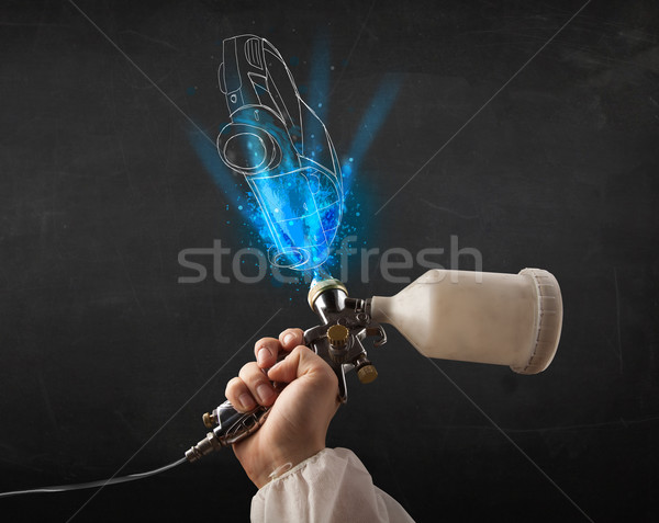 Worker with airbrush gun painting hand drawn car lines Stock photo © ra2studio