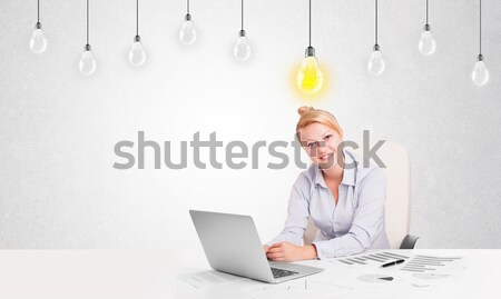 Business woman sitting at table with idea light bulbs Stock photo © ra2studio