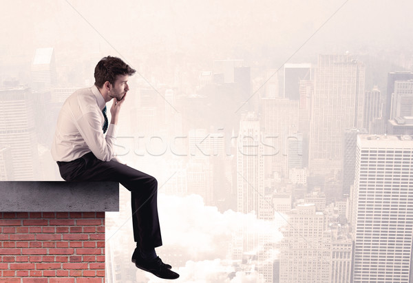 Office worker sitting on rooftop in city Stock photo © ra2studio