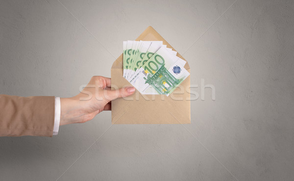 Hand holding envelope with empty wall background Stock photo © ra2studio