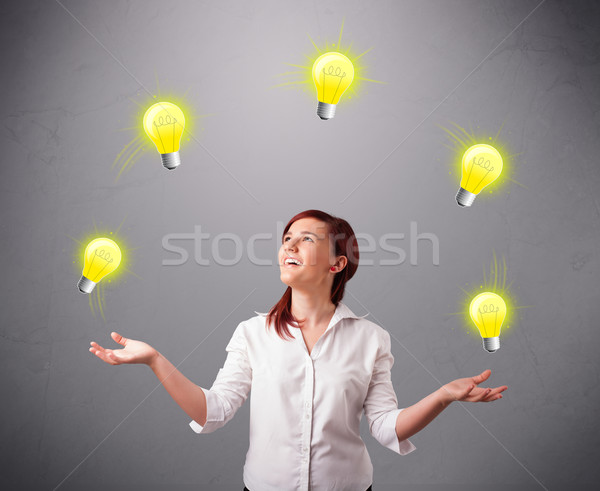 young lady standing and juggling with light bulbs Stock photo © ra2studio
