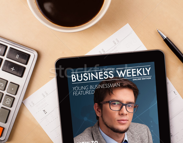 Workplace with tablet pc showing magazine cover and a cup of coffee on a wooden work table closeup Stock photo © ra2studio