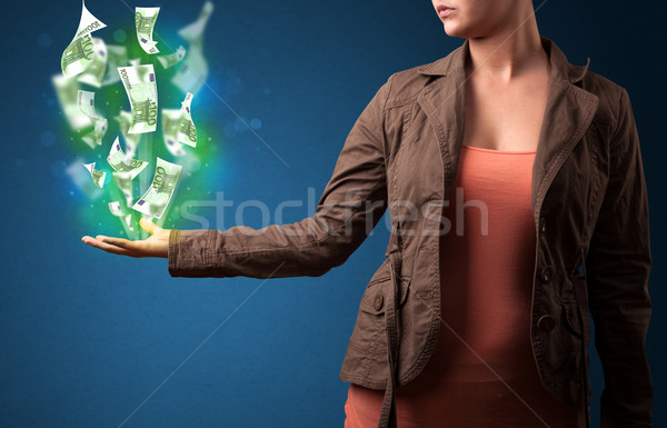 Stock photo: Glowing money in the hand of a woman