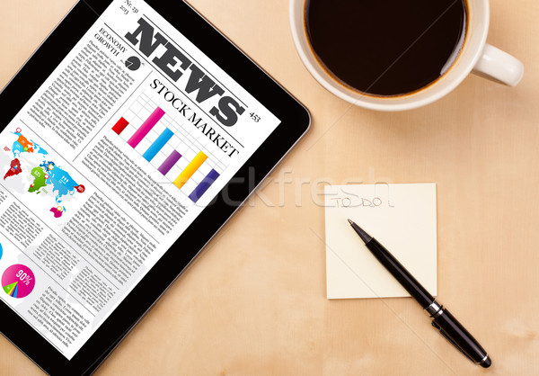 Tablet pc shows news on screen with a cup of coffee on a desk Stock photo © ra2studio