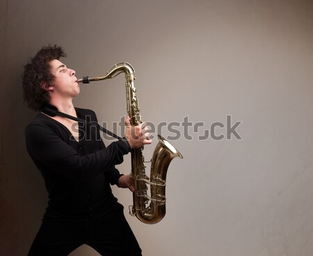 Young man playing on saxophone with copy space in white cloud Stock photo © ra2studio